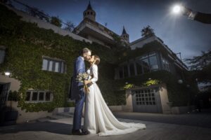 Los novios se besan frente al castillo cubierto de hiedra de la finca Monteviejo al caer la tarde