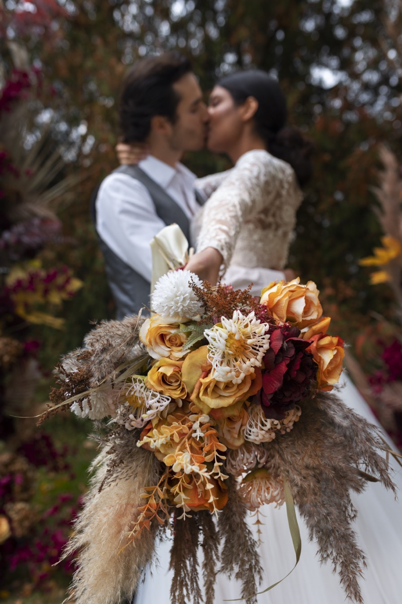 Pareja besándose en exterior, ángulo bajo — retrato de boda por Plasmalia