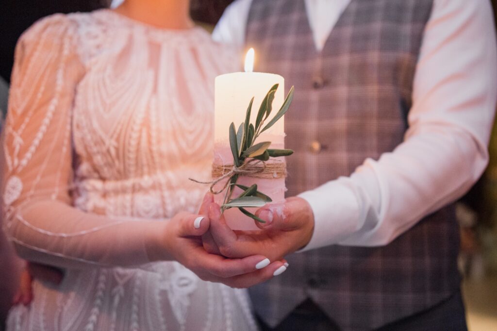 Novios encendiendo juntos la vela central en el ritual de la vela